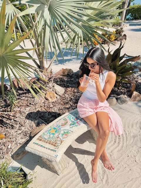 Aneesa enjoying a drink by the beach