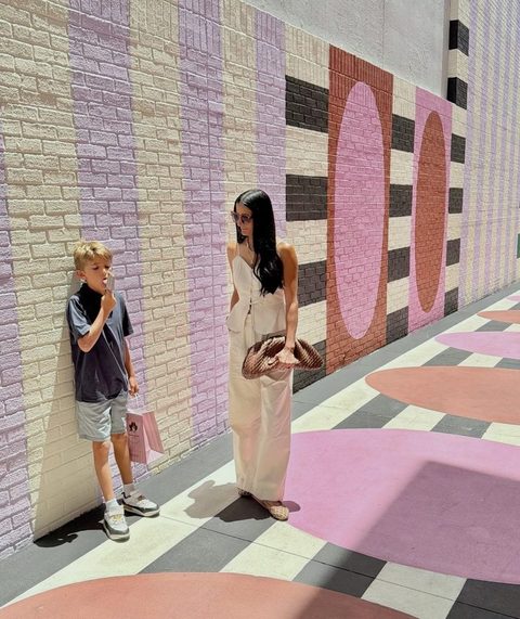 Aneesa with her son at a colorful mural